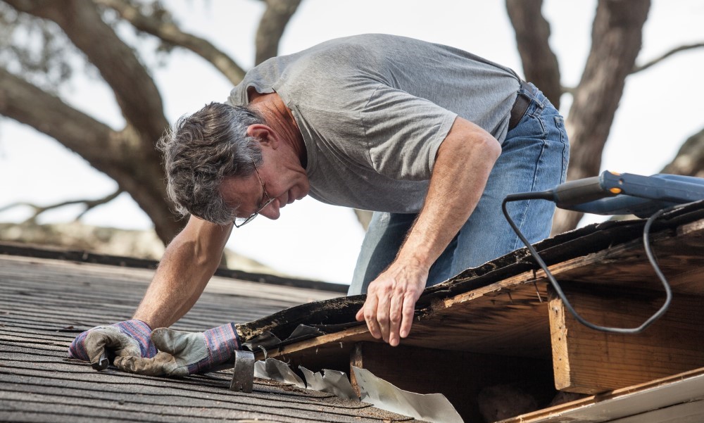 A man on a roof doing some repairs